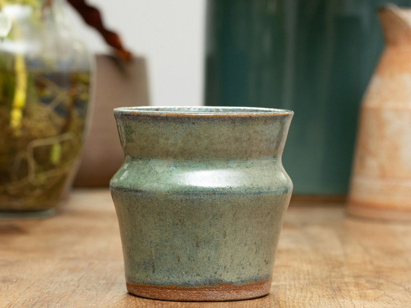 A handmade stoneware vase in a soft sea green glaze